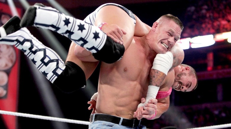 John Cena with CM Punk on his shoulders at WWE Night of Champions 2012