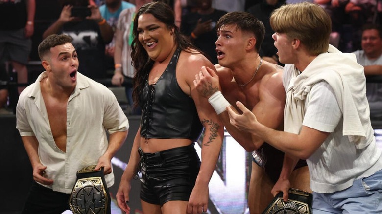 Myka Lockwood, flanked by the Vanity Project, stands proud of herself after body slamming Jasper Troy at ringside on an episode of "WWE NXT."