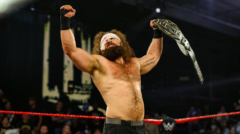 Tony D'Angelo holding up his fist and the WWE NXT Title