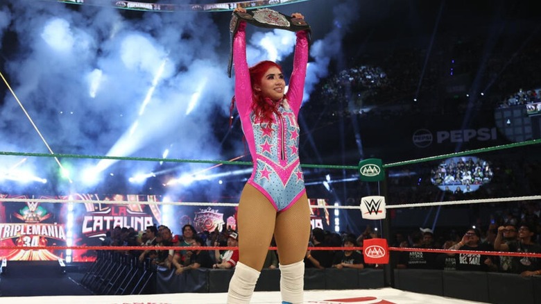 La Catalina holds up the AAA Reina de Reinas Championship after defeating Flammer at AAA TripleMania on September 13.