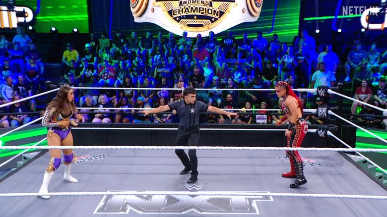 Sinclair and Zaria staring down one another in the ring