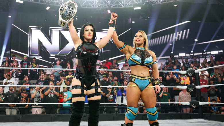 Jordynne Grace holds up Stephanie Vaquer's hand and eyes her NXT Women's Title