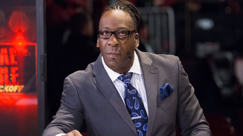 WWE Hall of Famer Booker T looks to the camera while broadcasting from the desk during a kick-off show for a WWE premium live event.