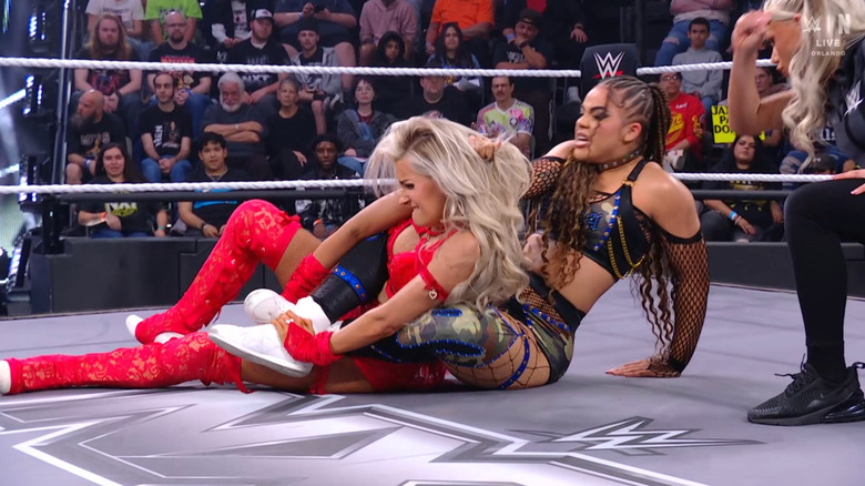 Parker wearing down Monroe with a submisison hold