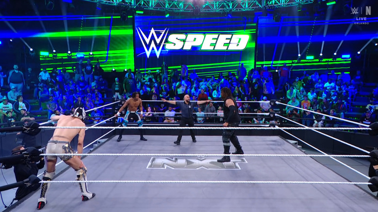 All three men staring down one another in the ring