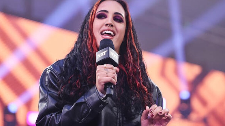 Ava speaks into a microphone on "WWE NXT"