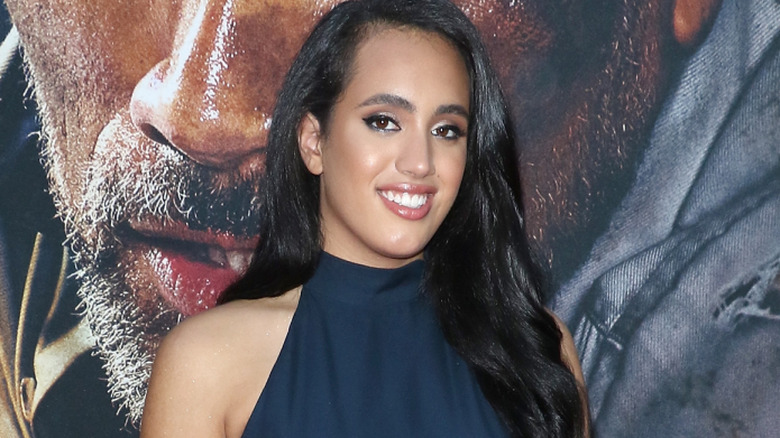 Ava, real name Simone Johnson, is wearing a black dress
