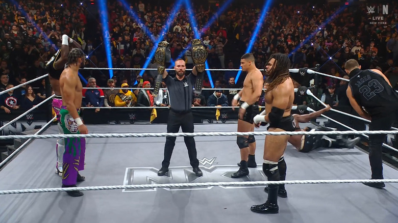 Slater, Evans, and DarkState in the ring staring one another down