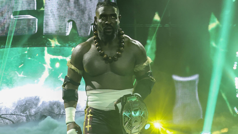 Oba Femi wearing a big necklace and holding his title