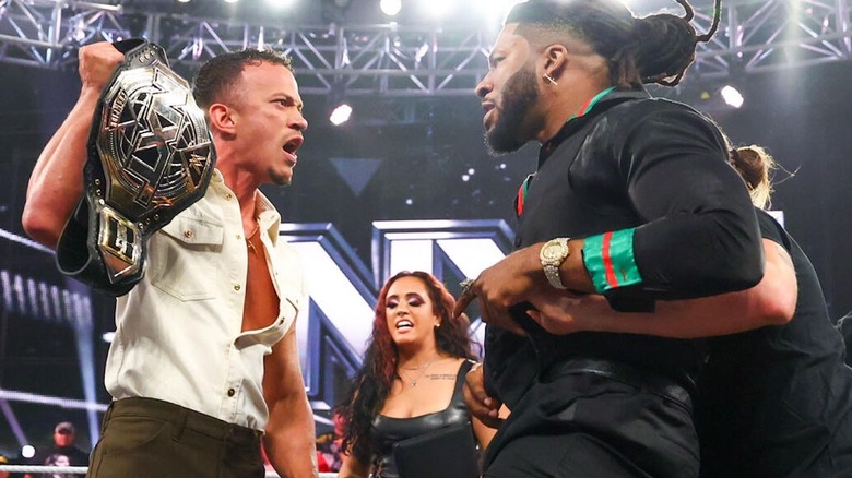 Trick Williams held back while Ricky Starks holds up his title on "WWE NXT"