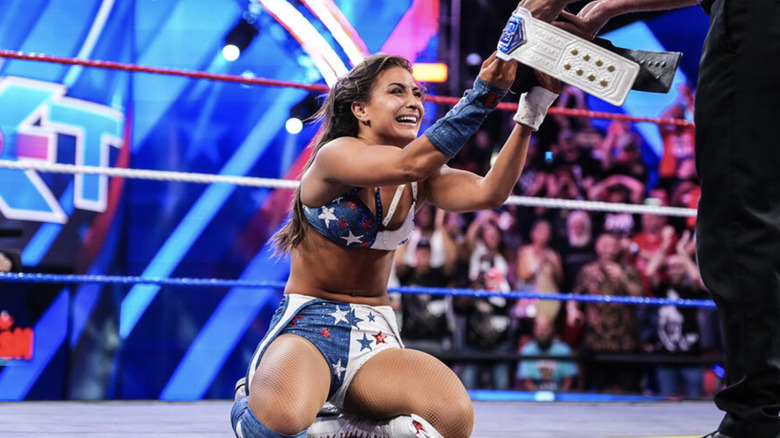 Grey kneeling in the ring as she's being handed her NXT Women's Championship
