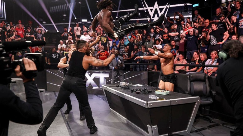 DarkState hit their finisher on Saquon Shugars, as Shugars hangs in the air before crashing through the commentary desk," during an episode of "WWE NXT."