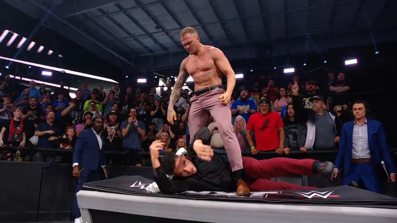 Borne standing over Page on the announce desk