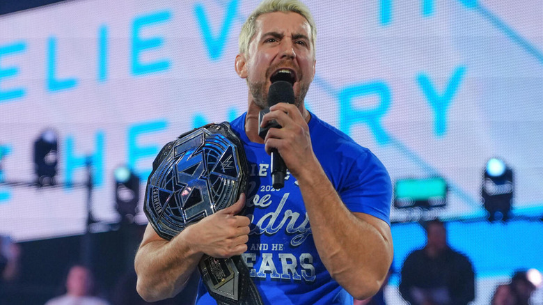 Joe Hendry shouts on the mic while holding the 