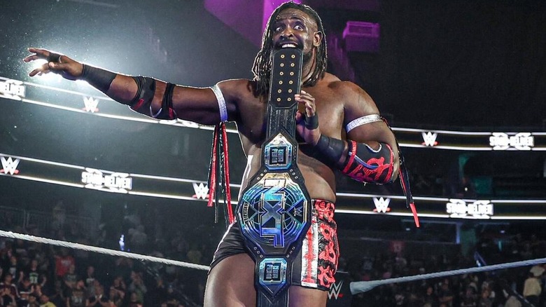 Oba Femi with the NXT Championship in his mouth