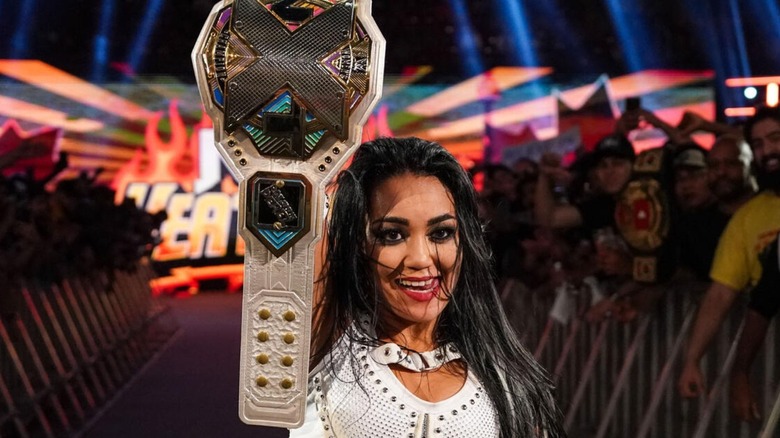 NXT Women's Champion Roxanne Perez stands with her championship in the air