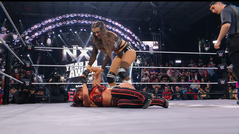 Sinclair standing over Jayne in the ring