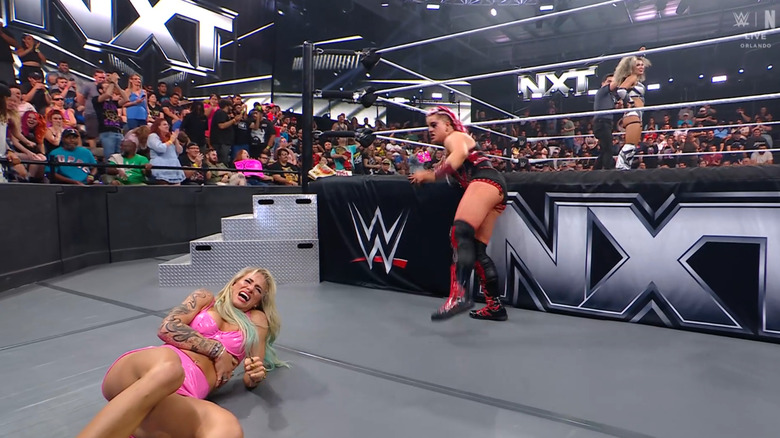 Zaria checking on Ruca as Jordan celebrates her win in the ring