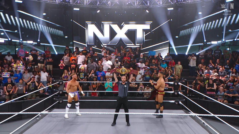 Page and Legacy in the ring as the referee holds up the North American Championship belt