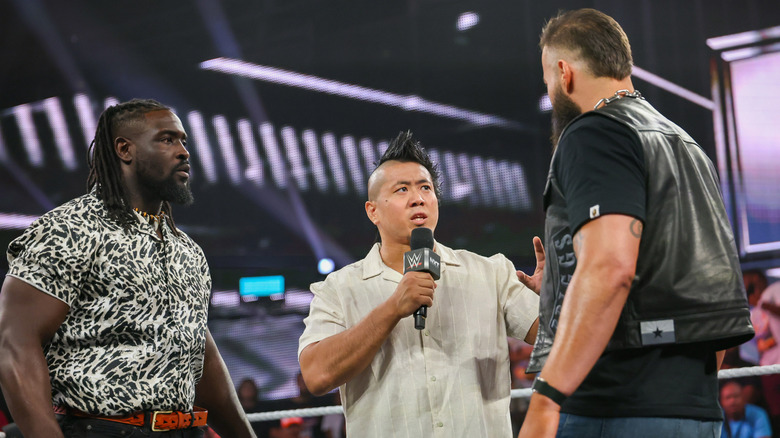 Femi, Inamura, and Briggs in the ring talking