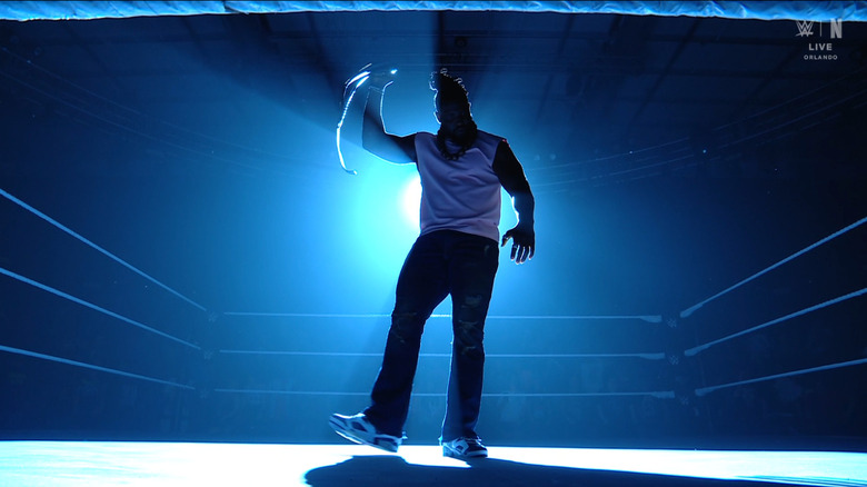 Femi standing in the ring holding up the NXT Championship belt