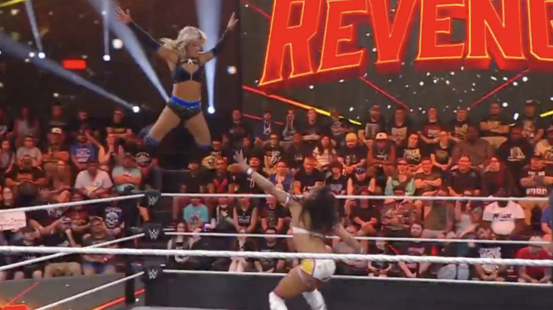 Raye flying off the ropes as Armstrong is about to land a forearm on her