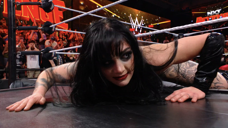 Tatum Paxley eerily peeks to the side as she lays on top of a casket.