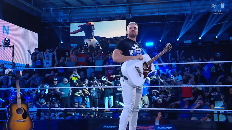 Hendry standing in the ring with his guitar