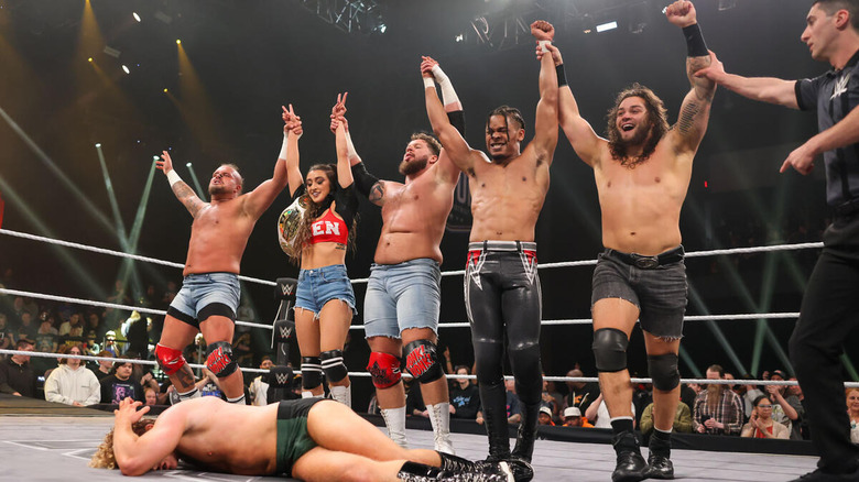 Hank & Tank, Wren Sinclair, EK Prosper, and Shiloh Hill stand above Charlie Dempsey with their arms raised