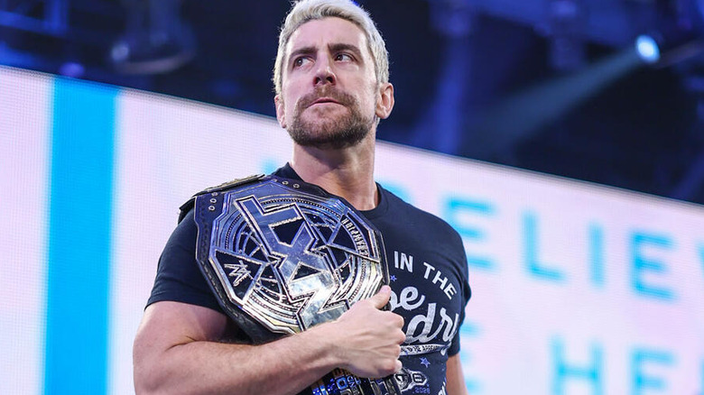 Joe Hendry looks menacingly up the ramp, the NXT Championship slung over his shoulder, during an episode of "WWE NXT."