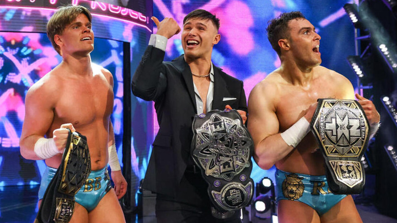 Brad Baylor, Jackson Drake, and Ricky Smokes all stand together as they hold the "NXT" Tag Team Championships (Smokes and Baylor) and the WWE Evolve Championship (Drake).