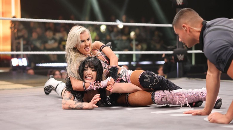 Blake Monroe puts Tatum Paxley in a submission hold in the middle of the ring, as the referee checks on Paxley, during the Women's North American Championship match at Stand & Deliver.