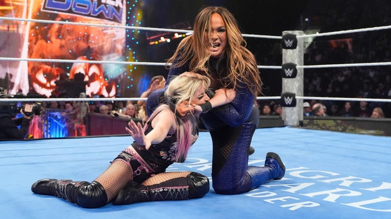 Nia Jax puts Alexa Bliss in a submission hold in the middle of the ring during a match on 