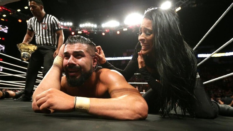 Andrade lays on the canvas in disbelief alongside Zelina Vega after defeating Drew McIntyre for the NXT Championship.
