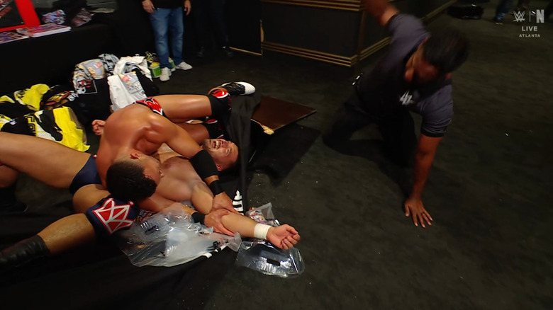 Saints pinning Page on top of a merchandise table