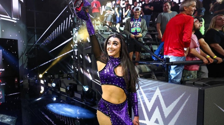 Wren Sinclair, dressed as AAA's Lady Shani, poses on the ramp, unmasked,, after winning the battle royale to become number one contender for the NXT Women's Championship on an episode of 