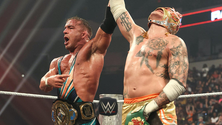 Chad Gable holds up Rey Fénix's arm