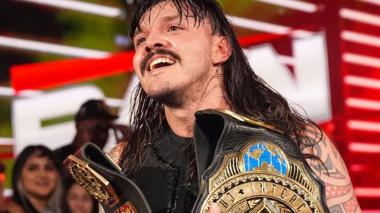 Intercontinental Champion Dominik Mysterio looks smiling to the ring while hold both of his titles on an episode of "WWE Raw."