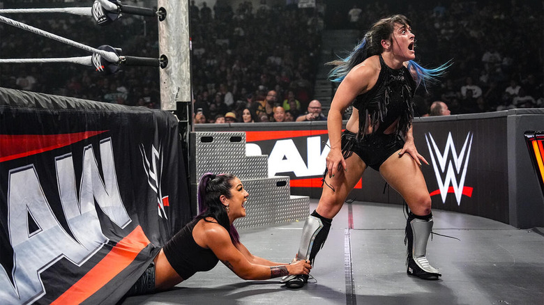 Bayley crawls out from under the ring to grab Lyra Valkyria's foot on "WWE Raw"