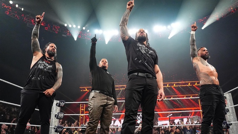 Roman Reigns, Solo Sikoa, and the Usos hold up their index fingers in the ring on "WWE Raw"