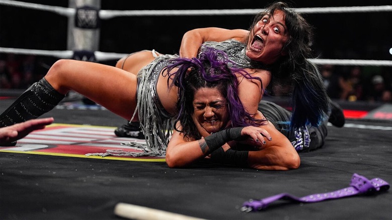 Lyra Valkyria with Bayley in a choke hold in the ring on "WWE Raw"