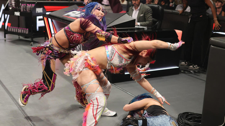 Kairi Sane intercepts IYO SKY's ringside beatdown of Asuka.