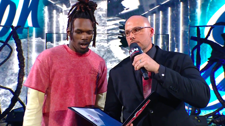 Adam Pearce presents Je'Von Evans with a contract