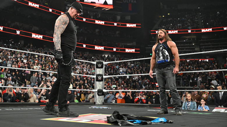Undertaker and AJ Styles look down at ring gear on "WWE Raw"