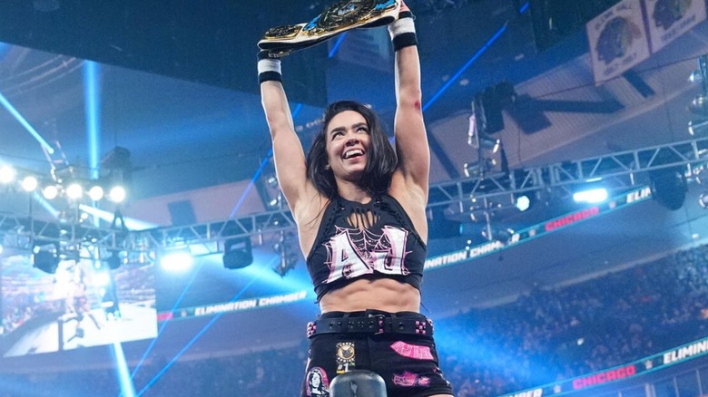 AJ Lee holds up the Women's Intercontinental Championship high while standing on the ropes after dethroning Becky Lynch at Elimination Chamber.
