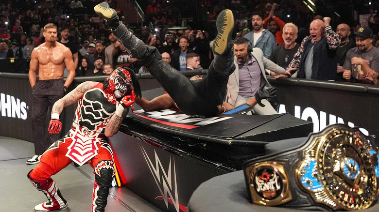 Penta drops Kofi Kingston onto the announce table while Grayson Waller looks on on "WWE Raw"