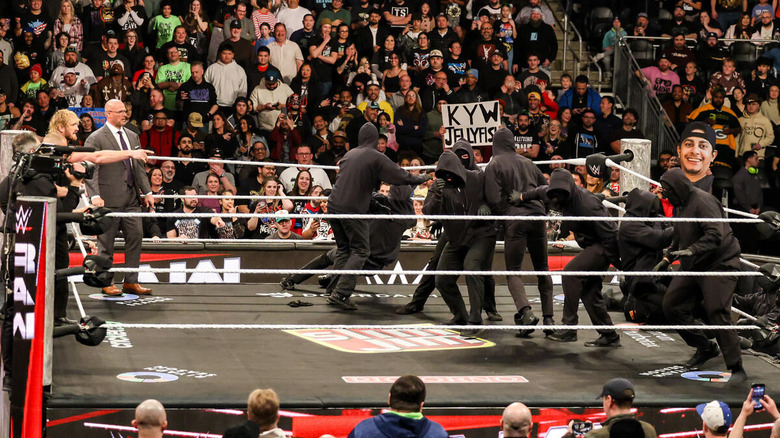 A horde of masked men in the ring on "WWE Raw"