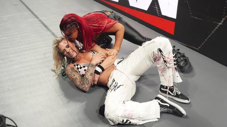 Zaria crouches over and whispers to a fallen Sol Ruca on "WWE Raw"