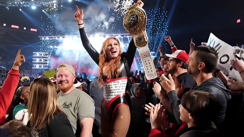 Becky Lynch celebrates in the crowd with her title