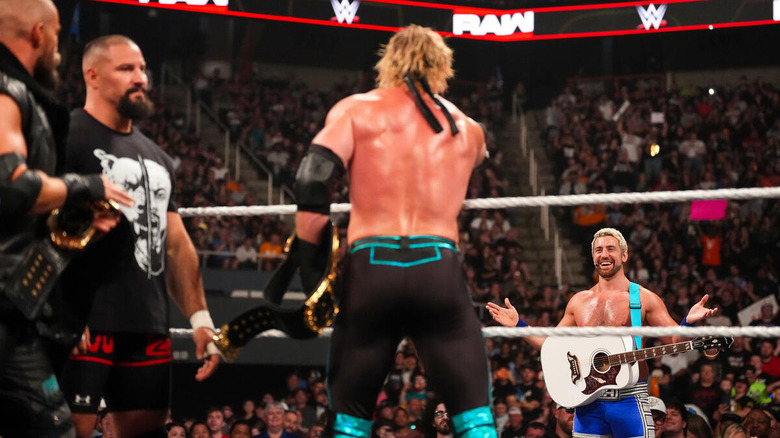 Joe Hendry stands with his guitar staring down the Vision inside the ring on "WWE Raw"